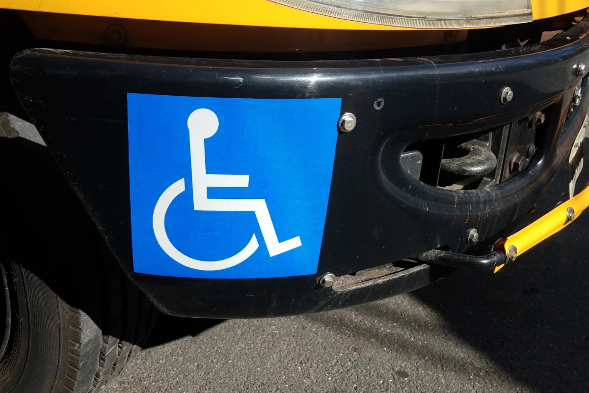 White on blue wheelchair symbol sticker on the bumper of a vehic