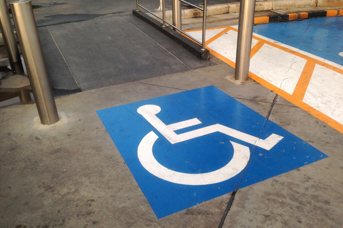 White on blue wheelchair symbol on the floor at the top of a wheelchair ramp