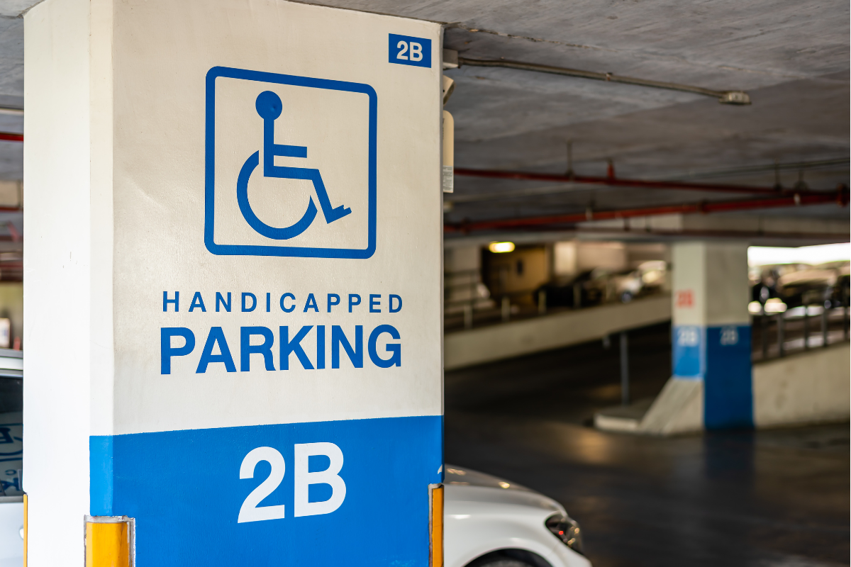 Blue on white wheelchair symbol marking a "Handicapped Parking" area of an indoor parking garage