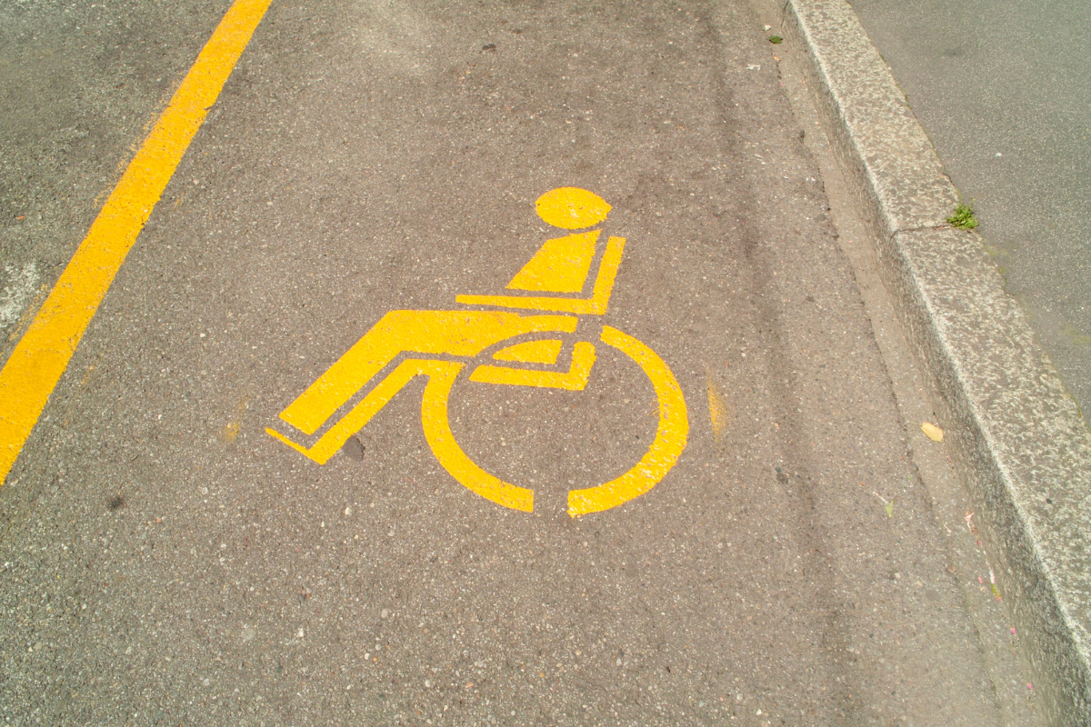 Yellow wheelchair symbols and lines marking accessible parking spaces