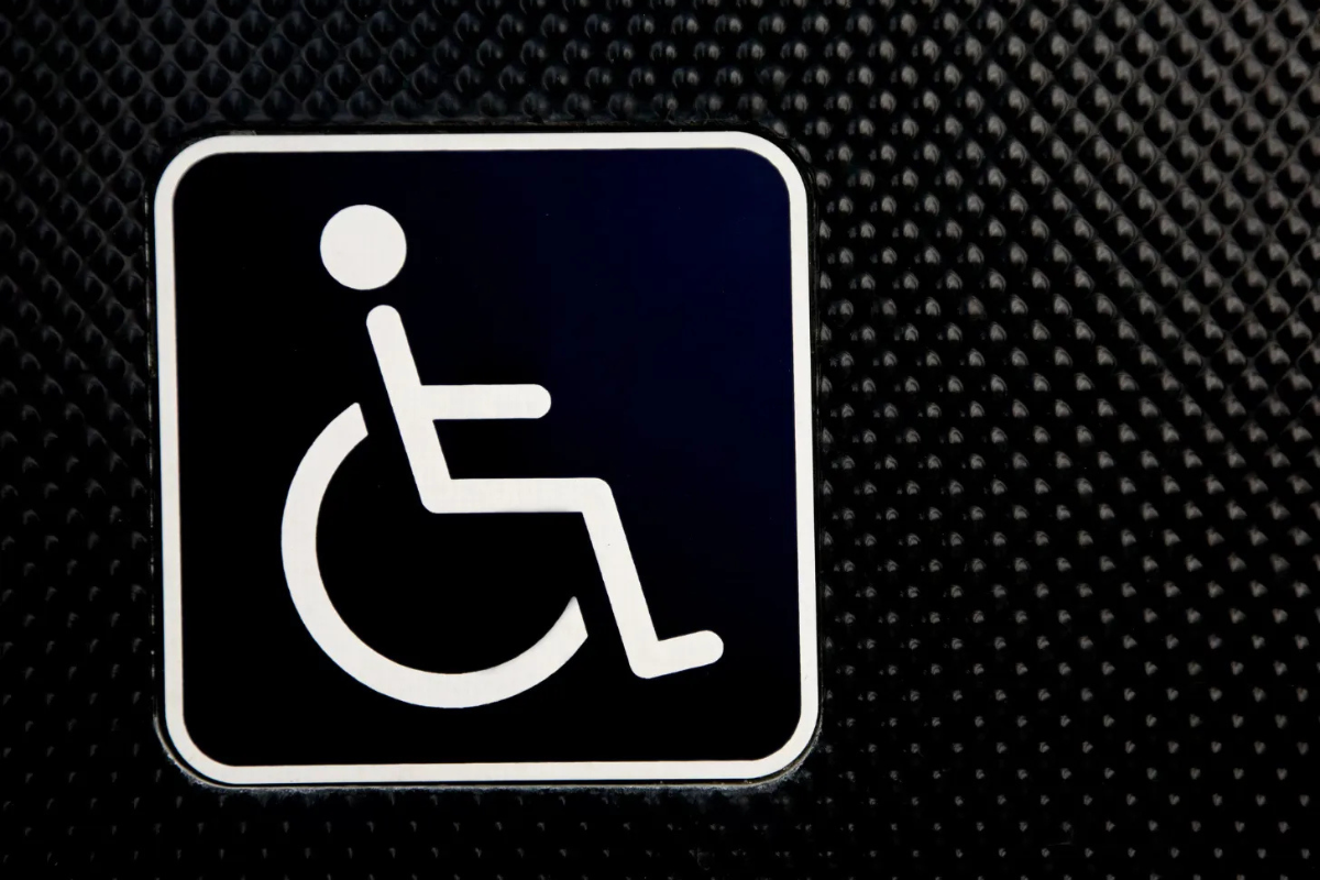 White wheelchair symbol on a black background