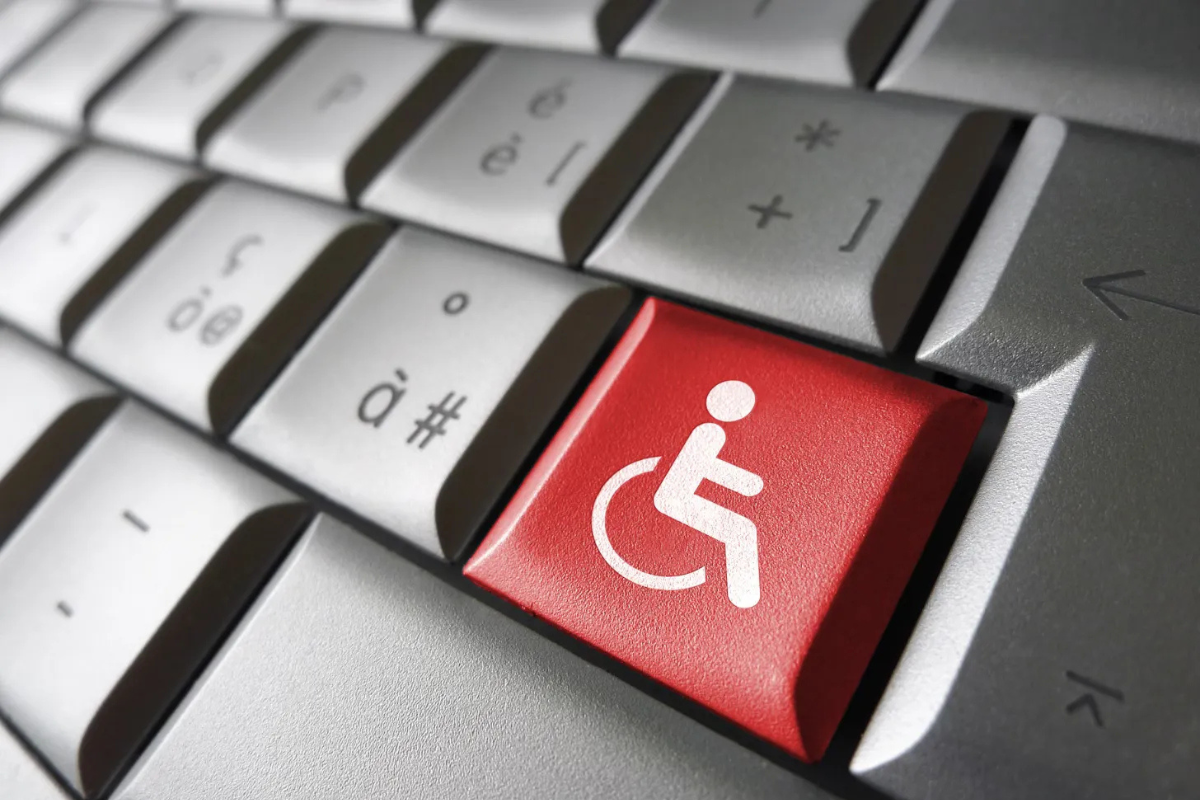 Closeup of a computer keyboard, one red key with a white wheelchair symbol