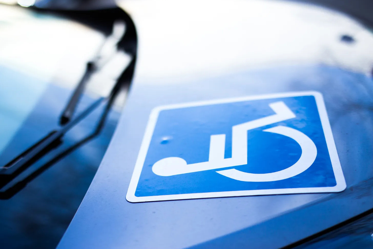 White on blue wheelchair symbol sticker on the hood of a car