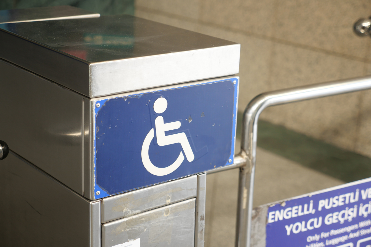 White wheelchair symbol on blue background sign on a turnstile
