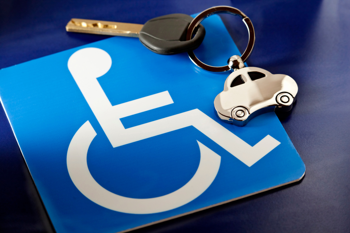 White on blue wheelchair symbol square coaster with car key nearby