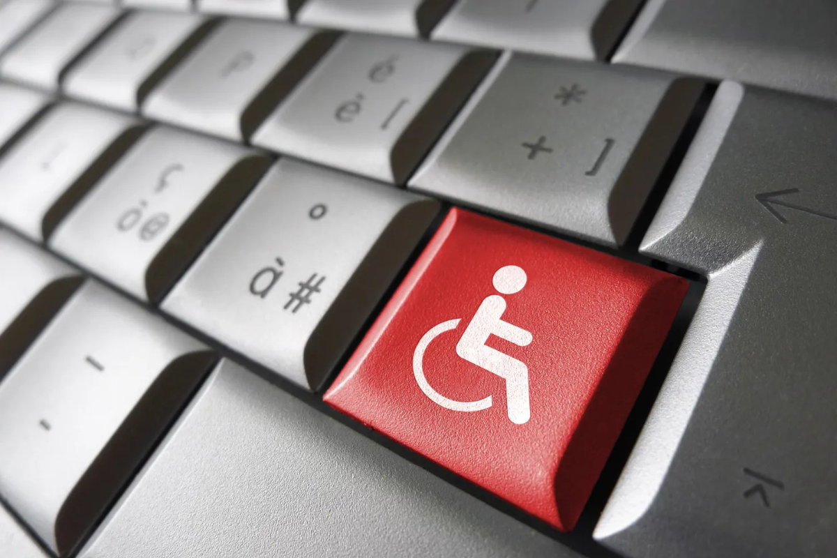 Closeup of a computer keyboard with a red key bearing a white wheelchair symbol