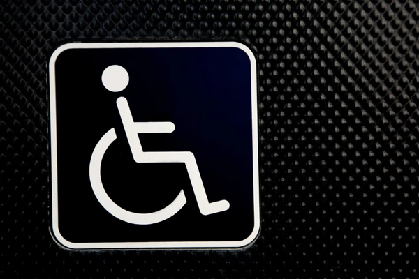 White wheelchair symbol on a black textured background