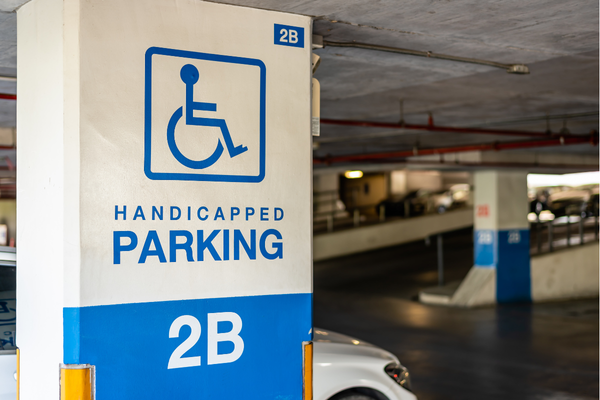 Wheelchair symbol sign marking an accessible parking zone in an indoor garage