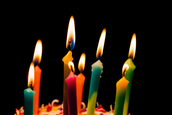 Closeup photo of a cluster of lit candles with a black background