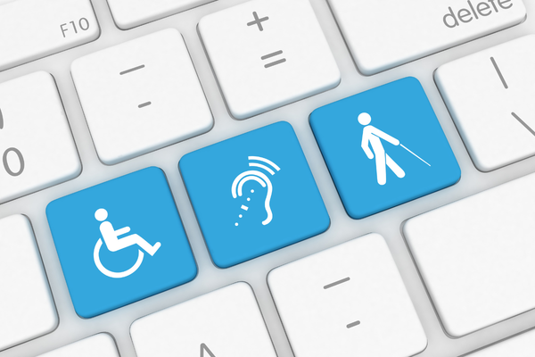 Closeup of computer keyboard with three blue keys in a row with white accessibility symbols - wheelchair, hearing aid, and white cane