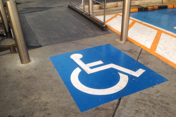 White on blue wheelchair symbol on the floor at the top of a wheelchair ramp