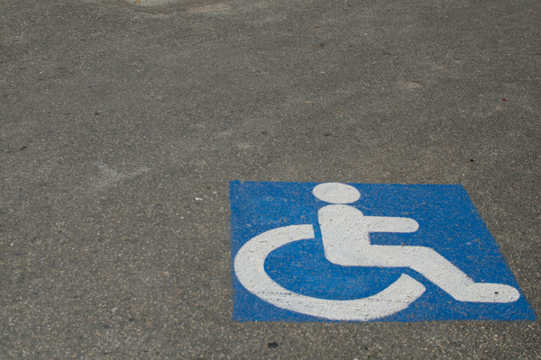 White on blue square sign pained onto cement parking space
