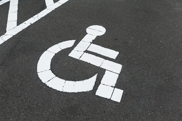 White wheelchair symbol on black pavement