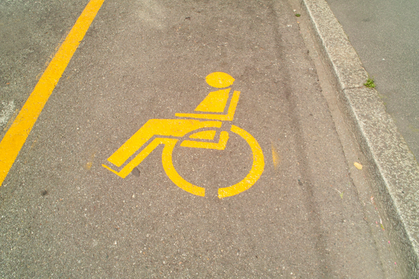 Yellow wheelchair symbols and lines marking accessible parking spaces