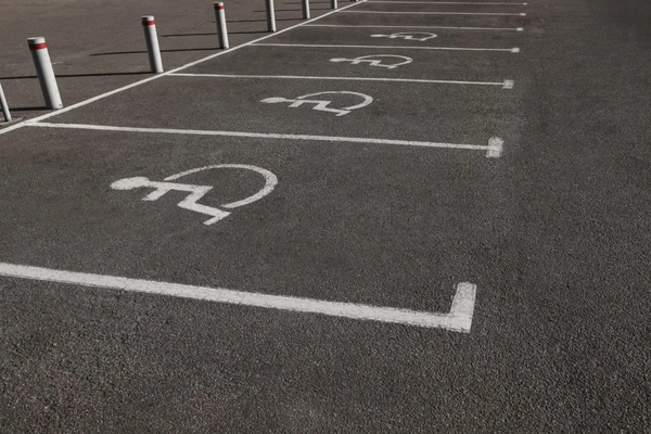 white wheelchair symbols and lines painted on pavement marking accessible parking spaces
