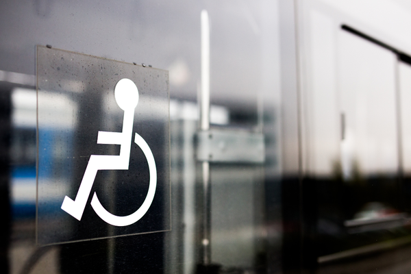 White wheelchair symbol on a reflective glass wall