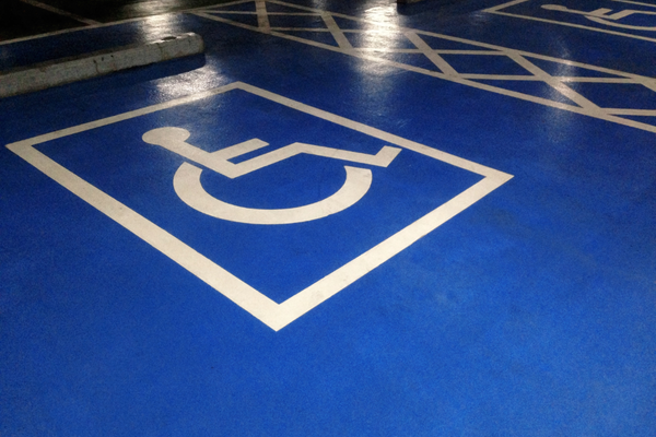 White wheelchair symbol marking a blue-colored indoor parking space